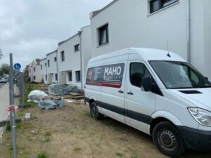 Maho Putztechnik Auto vor Häusern mit Außenputz.